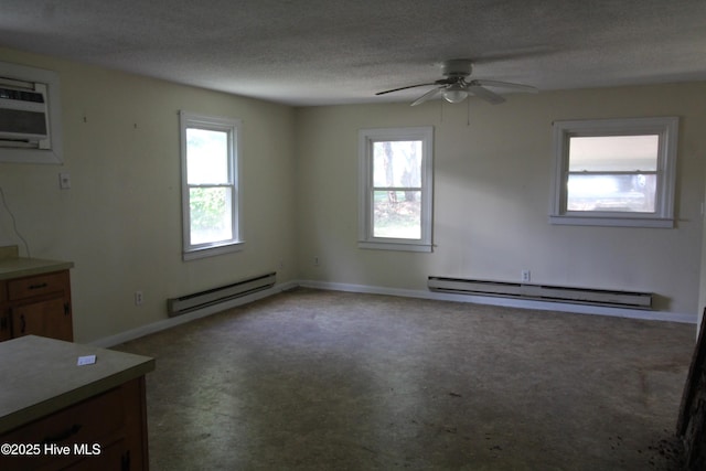 empty room with baseboard heating, a baseboard heating unit, plenty of natural light, a ceiling fan, and a textured ceiling