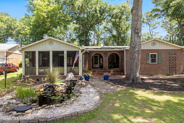212 Park Ave, Southport, NC 28461 - view of front of house with a sunroom, brick siding, and a front yard