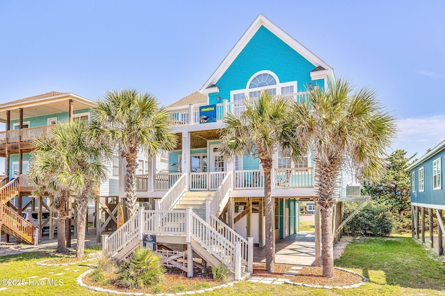 308 E Beach Dr, Oak Island, NC 28465 - rear view of house with stairway, a carport, a balcony, and covered porch