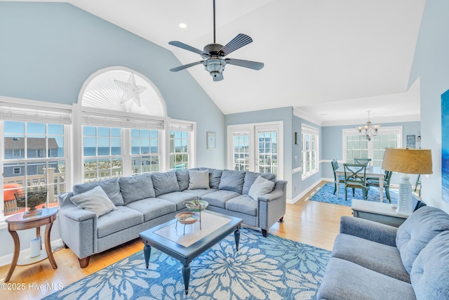 308 E Beach Dr, Oak Island, NC 28465 - living area with a chandelier, light wood-type flooring, baseboards, high vaulted ceiling, and a ceiling fan