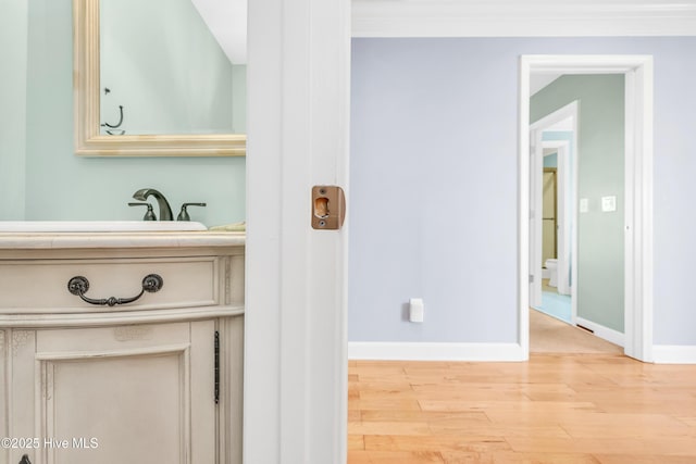308 E Beach Dr, Oak Island, NC 28465 - hallway with wood finished floors, baseboards, and a sink