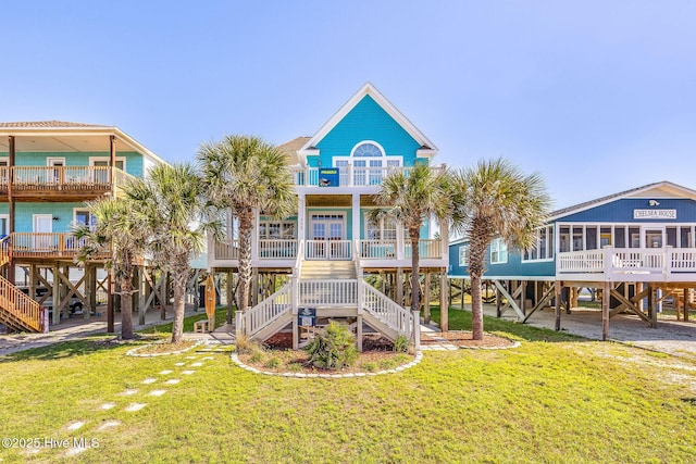 308 E Beach Dr, Oak Island, NC 28465 - rear view of property with a lawn, stairway, and covered porch