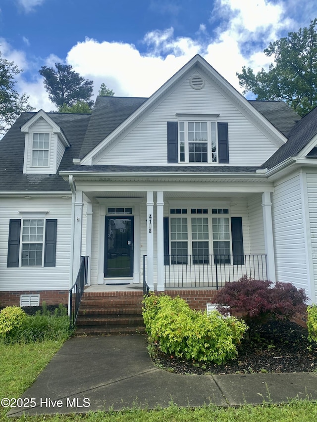 view of front of house with covered porch and a shingled roof