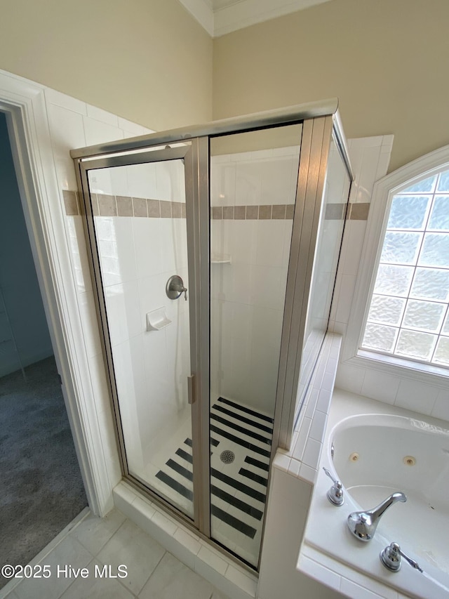full bathroom featuring a stall shower, a jetted tub, and tile patterned flooring