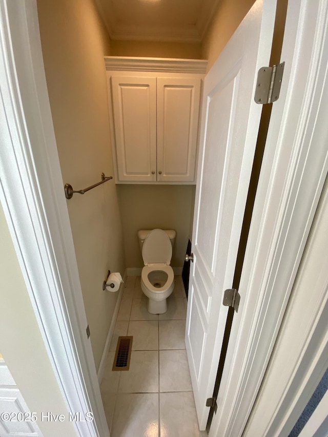 bathroom with ornamental molding, tile patterned flooring, toilet, and baseboards