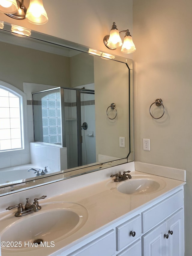 bathroom with double vanity, a stall shower, and a bath