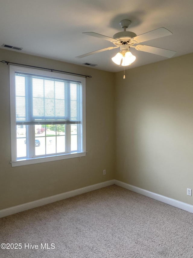 carpeted spare room with baseboards and a ceiling fan