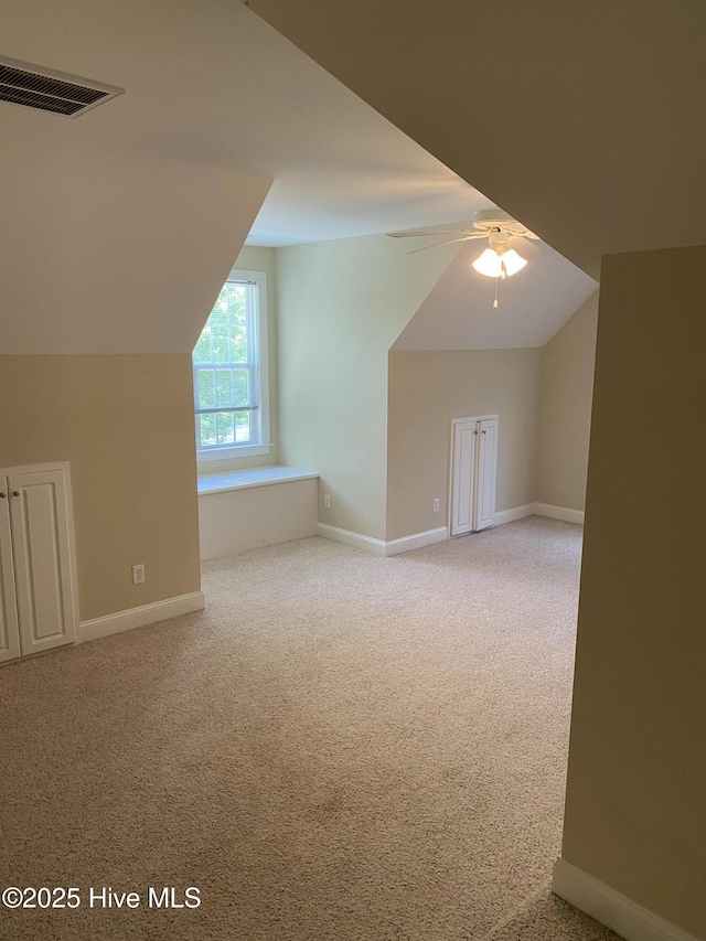 additional living space featuring carpet floors, lofted ceiling, a ceiling fan, and baseboards
