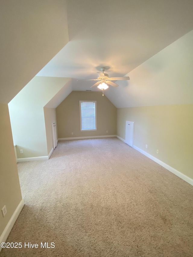 bonus room with light carpet, a ceiling fan, lofted ceiling, and baseboards