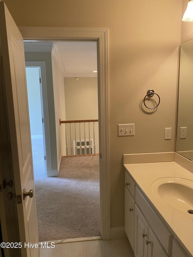 bathroom featuring vanity, ornamental molding, and baseboards