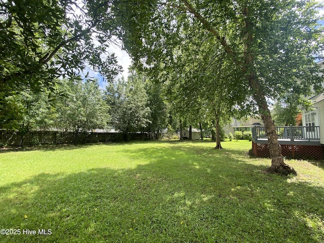 view of yard with a deck, an outdoor structure, and a shed