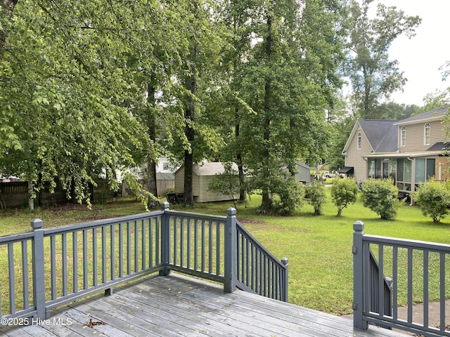wooden deck with a yard, an outbuilding, and a shed