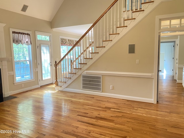 staircase featuring wood finished floors, vaulted ceiling, and baseboards