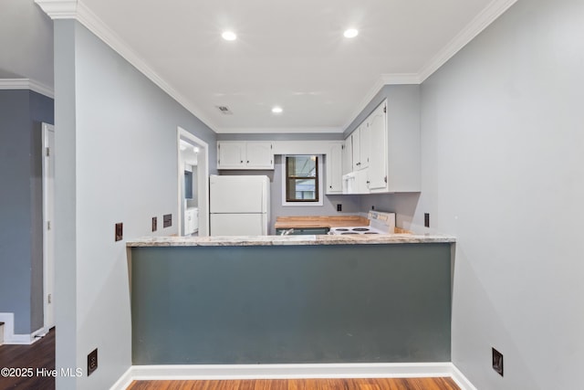 kitchen with white appliances, wood finished floors, white cabinetry, a peninsula, and recessed lighting