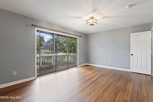 spare room featuring wood finished floors, baseboards, and a smoke detector