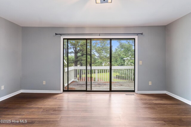 unfurnished room with wood finished floors and baseboards