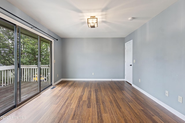 spare room featuring wood finished floors and baseboards