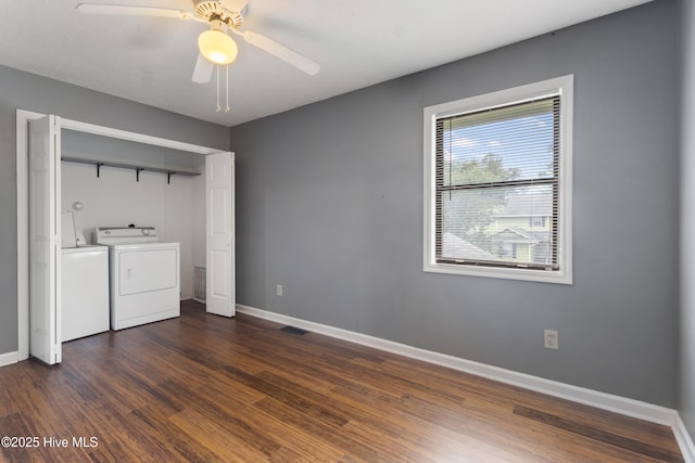 clothes washing area with washing machine and clothes dryer, baseboards, dark wood finished floors, and ceiling fan
