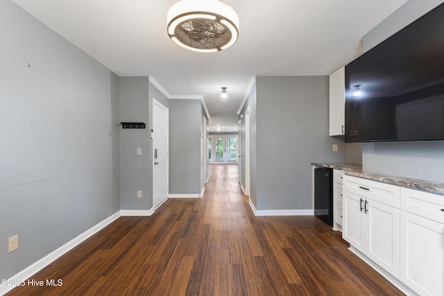 hall with baseboards, dark wood-style floors, and crown molding