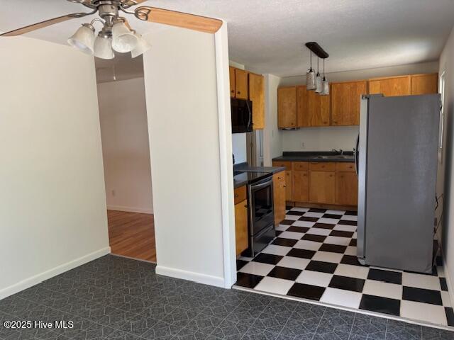 6007 Meadow Ln, Goldsboro, NC 27530 - kitchen with freestanding refrigerator, electric range, black microwave, dark countertops, and tile patterned floors