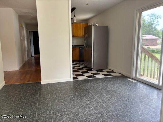 6007 Meadow Ln, Goldsboro, NC 27530 - kitchen featuring freestanding refrigerator, brown cabinets, dark flooring, black dishwasher, and baseboards
