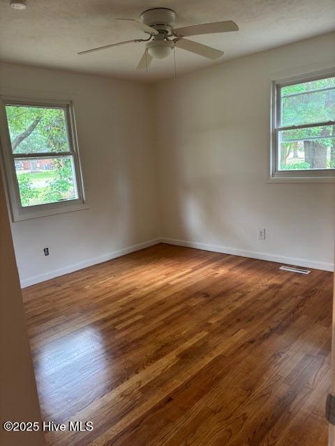 6007 Meadow Ln, Goldsboro, NC 27530 - unfurnished room featuring plenty of natural light, a ceiling fan, wood finished floors, and baseboards