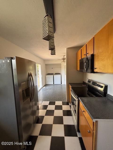 6007 Meadow Ln, Goldsboro, NC 27530 - kitchen with stainless steel appliances, dark flooring, brown cabinetry, separate washer and dryer, and a textured ceiling