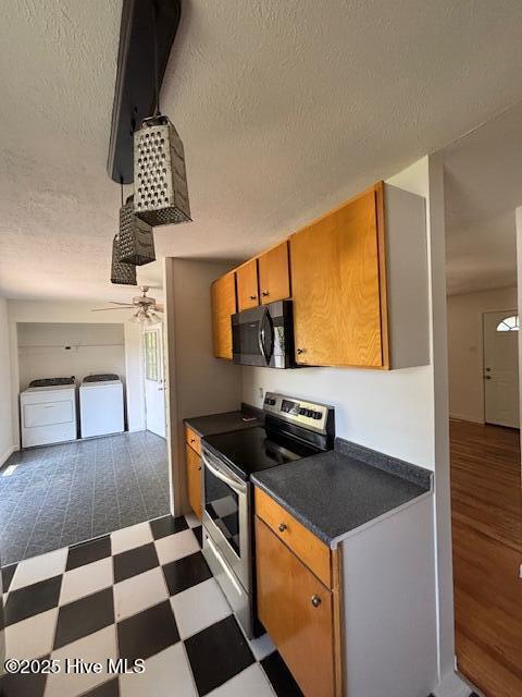 6007 Meadow Ln, Goldsboro, NC 27530 - kitchen featuring stainless steel electric range, dark countertops, washer and clothes dryer, dark floors, and a textured ceiling