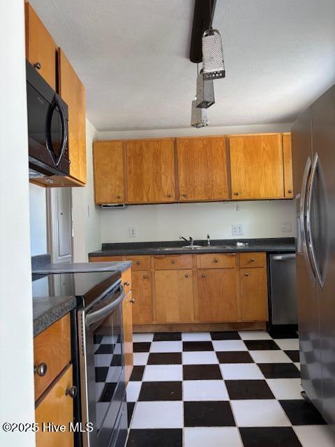 6007 Meadow Ln, Goldsboro, NC 27530 - kitchen with stainless steel appliances, light flooring, and brown cabinets