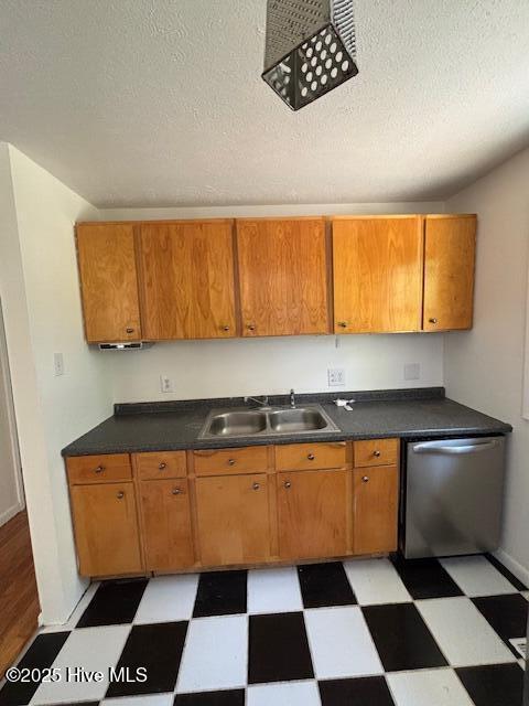 6007 Meadow Ln, Goldsboro, NC 27530 - kitchen featuring dishwasher, a sink, light flooring, brown cabinets, and a textured ceiling