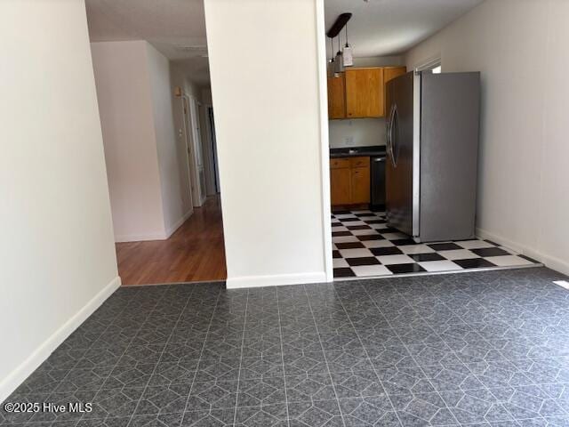 6007 Meadow Ln, Goldsboro, NC 27530 - kitchen featuring freestanding refrigerator, dark flooring, dishwasher, brown cabinetry, and baseboards