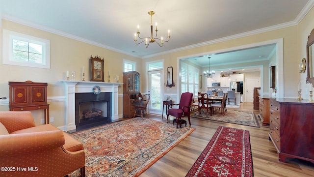 4083 Reunion Pointe Ln, New Bern, NC 28562 - living room featuring a chandelier, light wood-style floors, a fireplace with flush hearth, and ornamental molding