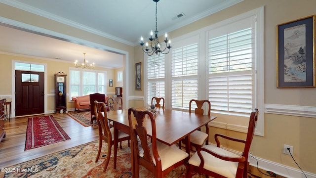 dining space with a chandelier, wood finished floors, and ornamental molding
