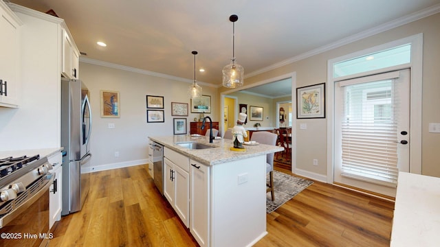 kitchen featuring a sink, appliances with stainless steel finishes, light wood-type flooring, white cabinetry, and crown molding