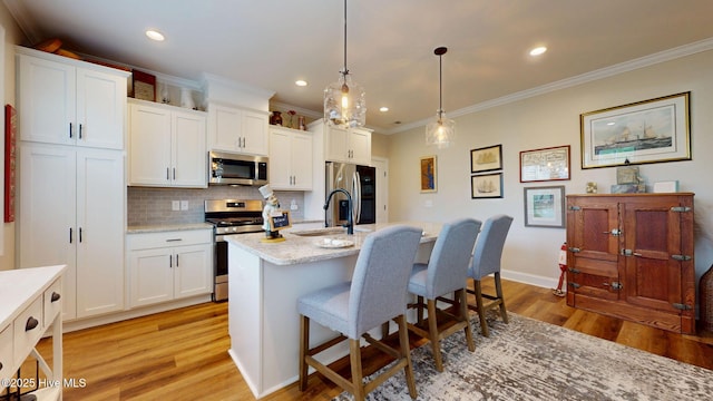 kitchen featuring stainless steel appliances, light wood-type flooring, a sink, decorative backsplash, and ornamental molding