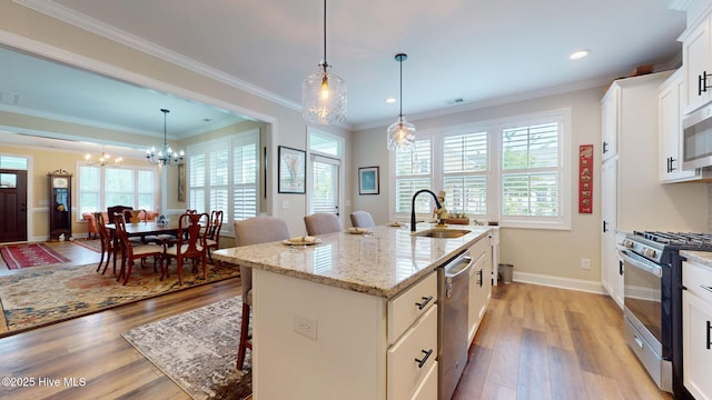 kitchen with appliances with stainless steel finishes, a sink, plenty of natural light, a kitchen breakfast bar, and recessed lighting