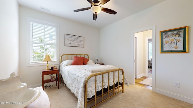 bedroom featuring light carpet, baseboards, and ceiling fan