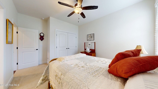 bedroom featuring light colored carpet, a closet, baseboards, and ceiling fan