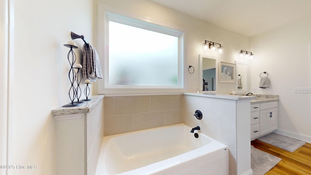 full bathroom with vanity, wood finished floors, and a bath