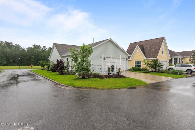view of side of home featuring driveway, a yard, and an attached garage