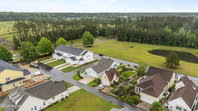 aerial view of residential area featuring a heavily wooded area and a nearby body of water