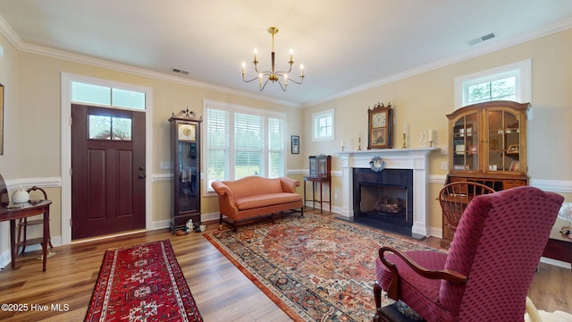 4083 Reunion Pointe Ln, New Bern, NC 28562 - living area featuring healthy amount of natural light, a chandelier, ornamental molding, wood finished floors, and a fireplace