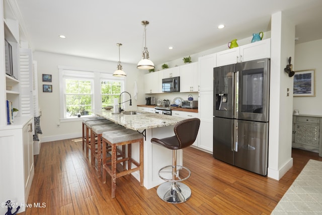 297 Broad St, Oriental, NC 28571 - kitchen with stainless steel fridge, black microwave, a sink, white cabinetry, and dark wood-style flooring