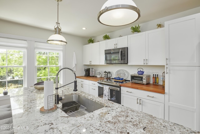 297 Broad St, Oriental, NC 28571 - kitchen with appliances with stainless steel finishes, butcher block countertops, a sink, white cabinets, and recessed lighting