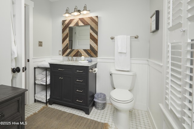 297 Broad St, Oriental, NC 28571 - bathroom featuring a wainscoted wall, toilet, vanity, a decorative wall, and tile patterned floors