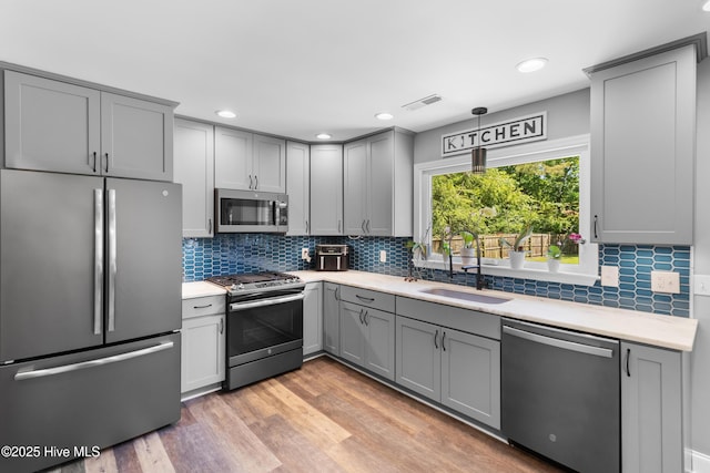 205 Sand Dollar Ln, Hampstead, NC 28443 - kitchen featuring appliances with stainless steel finishes, gray cabinets, light countertops, decorative backsplash, and recessed lighting