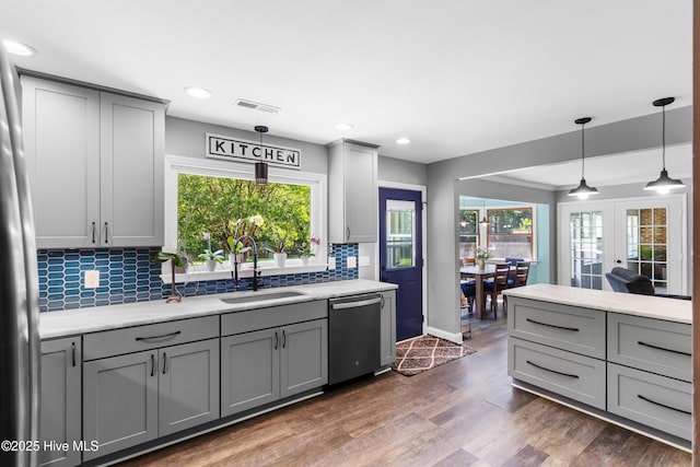205 Sand Dollar Ln, Hampstead, NC 28443 - kitchen featuring stainless steel appliances, gray cabinets, a sink, decorative backsplash, and plenty of natural light