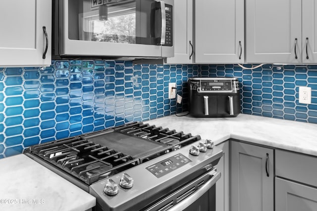 205 Sand Dollar Ln, Hampstead, NC 28443 - kitchen with gas stove, decorative backsplash, and light countertops