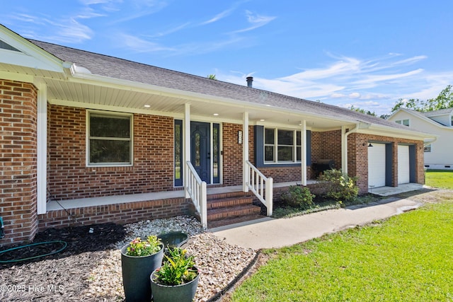 205 Sand Dollar Ln, Hampstead, NC 28443 - ranch-style house featuring an attached garage, a porch, and brick siding