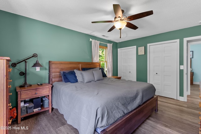 205 Sand Dollar Ln, Hampstead, NC 28443 - bedroom featuring wood finished floors, two closets, baseboards, and a ceiling fan